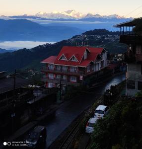 ein Gebäude mit rotem Dach und vorne geparkt in der Unterkunft Swarna Kamal Homestay in Darjeeling