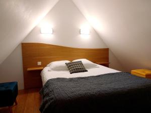 sypialnia z łóżkiem z dwoma światłami na ścianie w obiekcie Auberge des Goubelins w mieście Omonville-la-Rogue