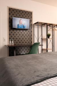a bedroom with a bed and a television at Hotel Burgblick in Bonn