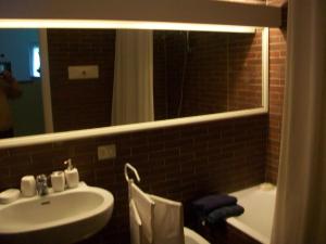 a bathroom with a sink and a tub and a mirror at B&B L'Albero Maestro in Orsenigo