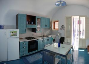 a kitchen with blue cabinets and a white refrigerator at Casa Cipolla in San Vito lo Capo