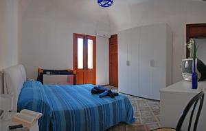 a bedroom with a bed with a blue blanket at Casa Cipolla in San Vito lo Capo