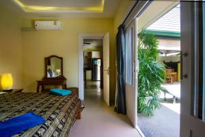 1 dormitorio con 1 cama y puerta que conduce a un pasillo en Villa Topaz, en Laem Set Beach 39 fotos más