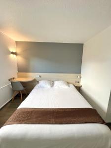 ein Schlafzimmer mit einem großen Bett und einem Schreibtisch in der Unterkunft Kyriad Direct Reims Bezannes in Reims