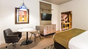 une chambre d'hôtel avec un lit, une table et une chaise dans l'établissement Hotel Indigo Hattiesburg, an IHG Hotel, à Hattiesburg