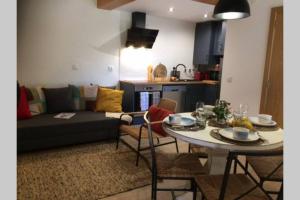 a kitchen and a living room with a table and a couch at Casa da Travessa do Casal in Alqueve