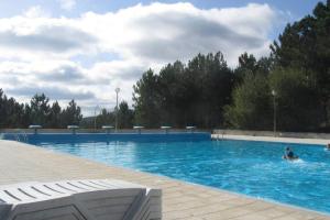 a person swimming in a large swimming pool at Casa da Travessa do Casal in Alqueve