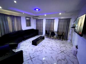 a living room with a couch and a table at CG Apartments Metro in Ikeja