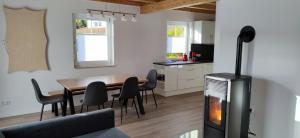 a living room with a dining room table with a fireplace at Haus Brückelsee in Wackersdorf
