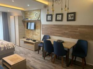 a living room with a dining room table and chairs at Milmari Premier40 in Kopaonik