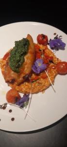 une assiette de nourriture avec des légumes et des fleurs sur elle dans l'établissement Hôtel-Restaurant Le Lion d'Or, à Porrentruy