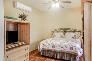 a bedroom with a bed and a flat screen tv at Casa Chica FN320 at Loreto Bay in Loreto