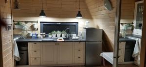 a kitchen with a sink and a refrigerator at Na Zakręcie - Domek Wiejski in Błędowo