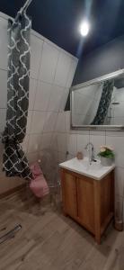 La salle de bains est pourvue d'un lavabo et d'un miroir. dans l'établissement Na Zakręcie - Domek Wiejski, à Błędowo