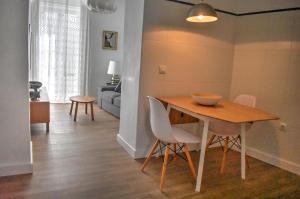 a dining room and living room with a table and chairs at Apartamentos Las Naranjas in Jerez de la Frontera