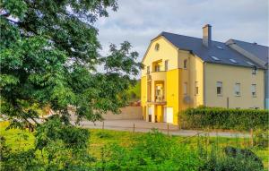 a yellow house with a black roof at 2 Bedroom Awesome Apartment In Winseler in Winseler