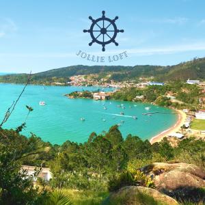 a view of a beach with a boat in the water at Loft para locação em Calheiros Governador Celso Ramos in Governador Celso Ramos