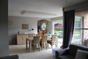 a kitchen and dining room with a table and chairs at Le grand marronnier in Neuville