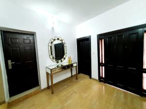 a room with two black doors and a mirror at Epic Prime Apartments in Ikeja