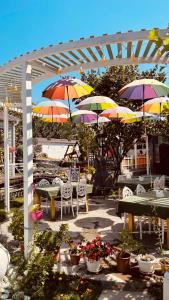 a patio with tables and chairs with umbrellas at Qafqaz Fountain Villa in Gabala