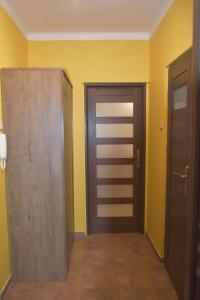 un pasillo con dos puertas y paredes amarillas en Apartament Joanna, en Świnoujście