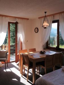 una sala da pranzo con tavolo e alcune finestre di Ferienhaus Dr. Schorm a Schruns