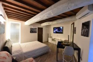 a bedroom with a bed and a desk and a tv at Monolocale su Corso Vannucci 2+2 in Perugia