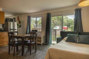 a bedroom with a bed and a table and a kitchen at Puu Koa Palms vacation rental in Haiku