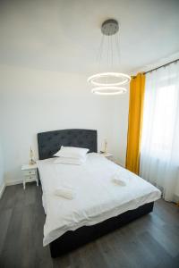 Un dormitorio con una cama grande con una gran colcha blanca en Central Nest, en Turda