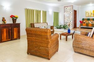 a living room with several chairs and a table at Recanto do Village in Porto Seguro