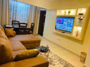 a living room with a couch and a flat screen tv at Eastleigh Executive Furnished Apartments next to BBS Mall in Nairobi