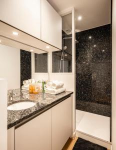 La salle de bains est pourvue d'un lavabo et d'une douche. dans l'établissement Studio cosy Hounau - Garage privatif, à Pau