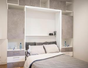 a bedroom with a large bed with white cabinets at Studio cosy Hounau - Garage privatif in Pau