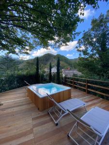a hot tub on a wooden deck with two chairs at Il borgo Casteldelci in Casteldelci
