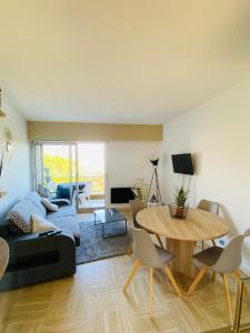 a living room with a couch and a table at Appartement côte d’Azur Plage - piscine - tennis in Villeneuve-Loubet +24 photos