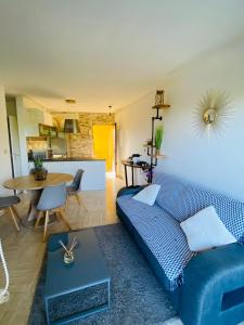 a living room with a blue couch and a table at Appartement côte d’Azur Plage - piscine - tennis in Villeneuve-Loubet