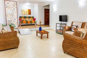 a living room with several chairs and a tv at Recanto do Village in Porto Seguro