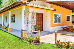 a house with a colorful fence in the yard at Recanto do Village in Porto Seguro