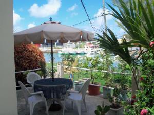 een tafel en stoelen met een parasol op een balkon bij Villa Acajou sur Mer in Rodrigues Island