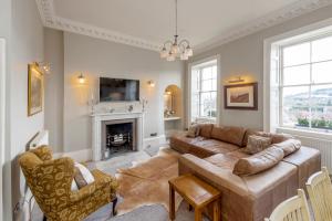 a living room with a couch and a fireplace at Luxury Georgian Duplex in Central Bath in Bath