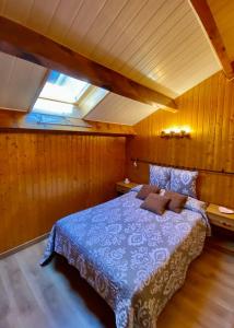 a bedroom with a blue bed in a room with wooden walls at Charmant T3 "les Cerdans" in Porté-Puymorens