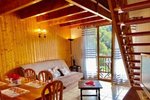 a living room with a couch and a table with chairs at Charmant T3 "les Cerdans" in Porté-Puymorens