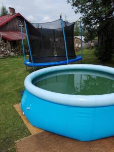 a blue pool of water with a tent in the background at Apartament Ruska Bania Na Pograniczu in Lasowka