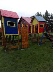 a row of colorful play houses in the grass at Na Pograniczu domek w górach in Lasowka