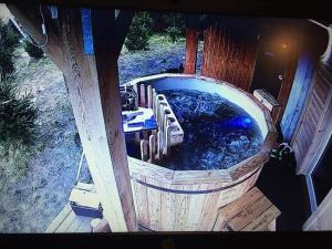 a large hot tub with chairs in a wooden tub at Na Pograniczu domek w górach in Lasowka +4 photos