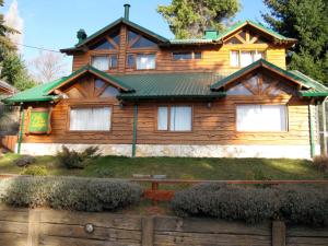 a wooden house with a green roof at Villa del Lago in San Carlos de Bariloche