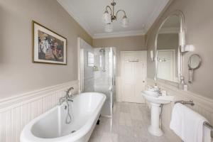 een witte badkamer met een bad en een wastafel bij Luxury Georgian Duplex in Central Bath in Bath