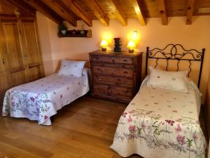 a bedroom with two beds and a dresser with two lamps at La Casa de Bernuy in Bernúy de Porreros