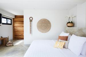 um quarto com uma cama branca com almofadas em Villa Selalu em Gili Gede