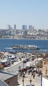 a group of people walking around a parking lot near the water at ÜSKÜDAR OTEL in Istanbul